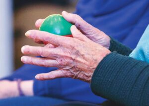 older hands holding a ball